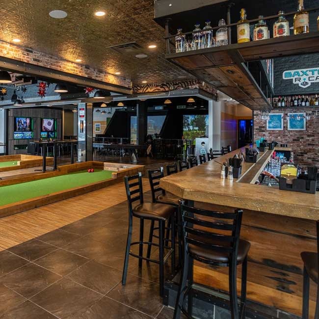 Bar area with wooden counters, high chairs, and indoor bocce courts—featured in Southpointe PA Magazine.