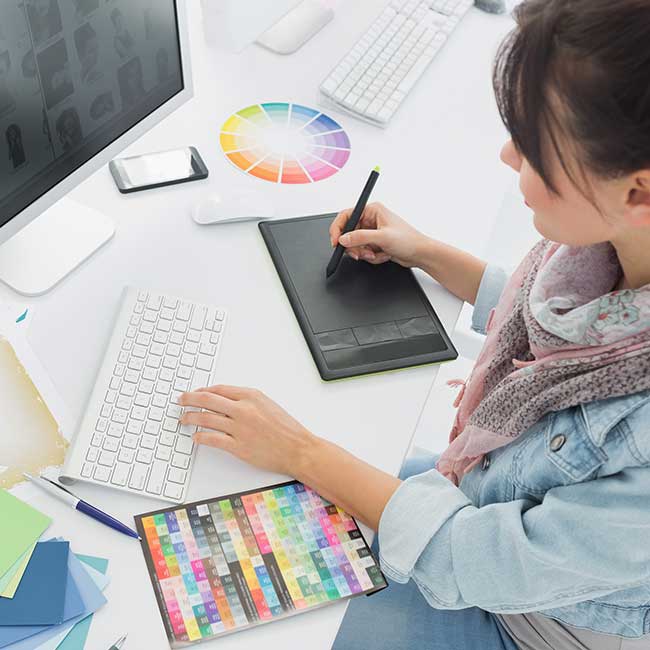 Person using a graphic tablet and keyboard, featured in Southpointe PA Magazine at their desk.