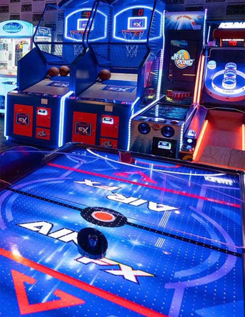 Arcade basketball and air hockey glow under neon lights at Southpointe PA Magazine events.
